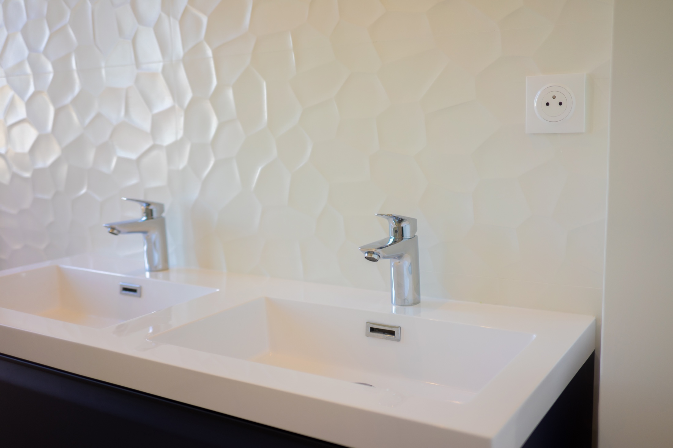 Double vasque et finitions murales dans une salle de bains rénovée.