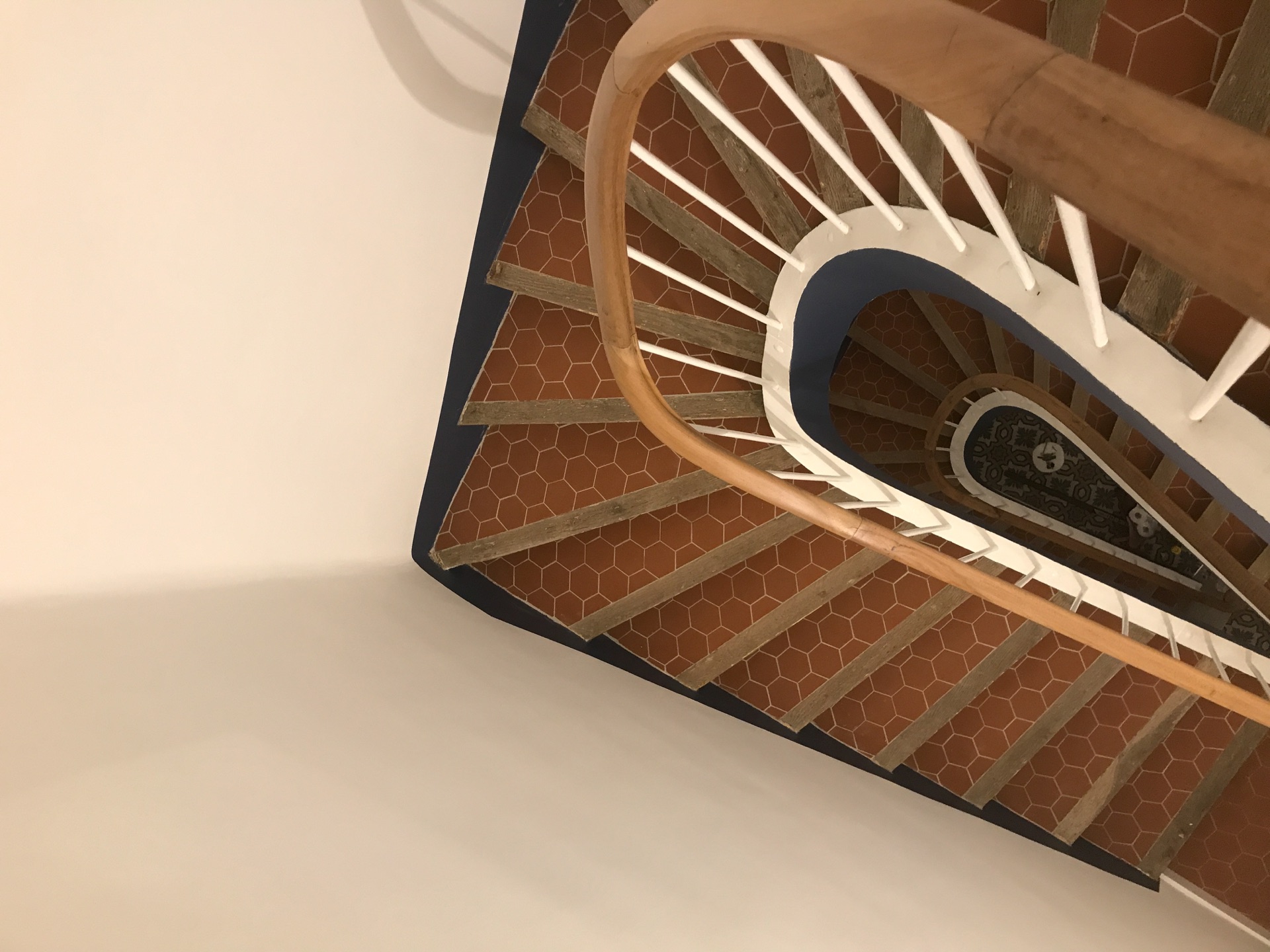 Vue plongeante sur un escalier intérieur et sa rampe en bois