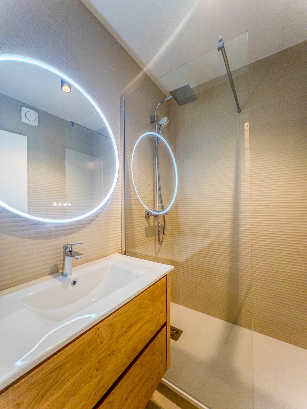 Salle d’eau avec douche vitrée et meuble vasque.