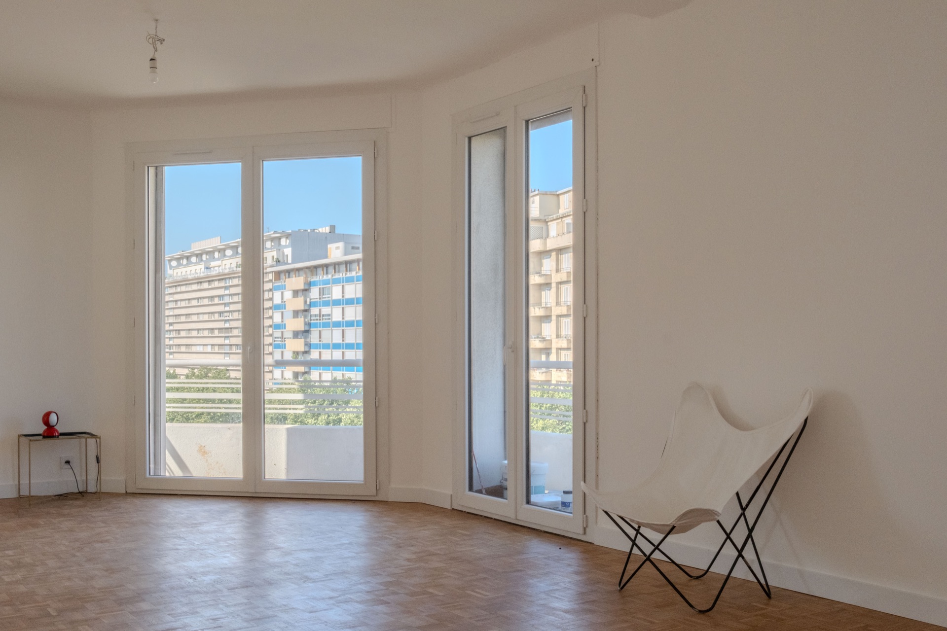 Pièce de vie avec fenêtres ouvertes sur un balcon